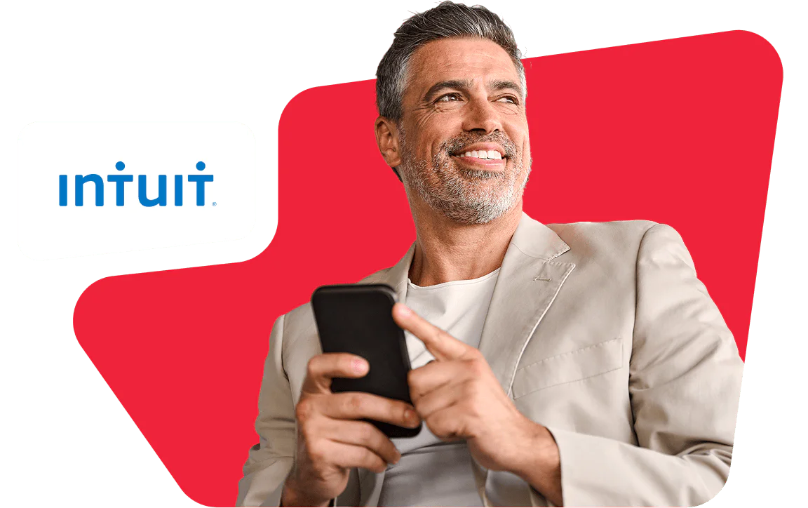 Smiling man holding a smartphone with Intuit logo in the background.