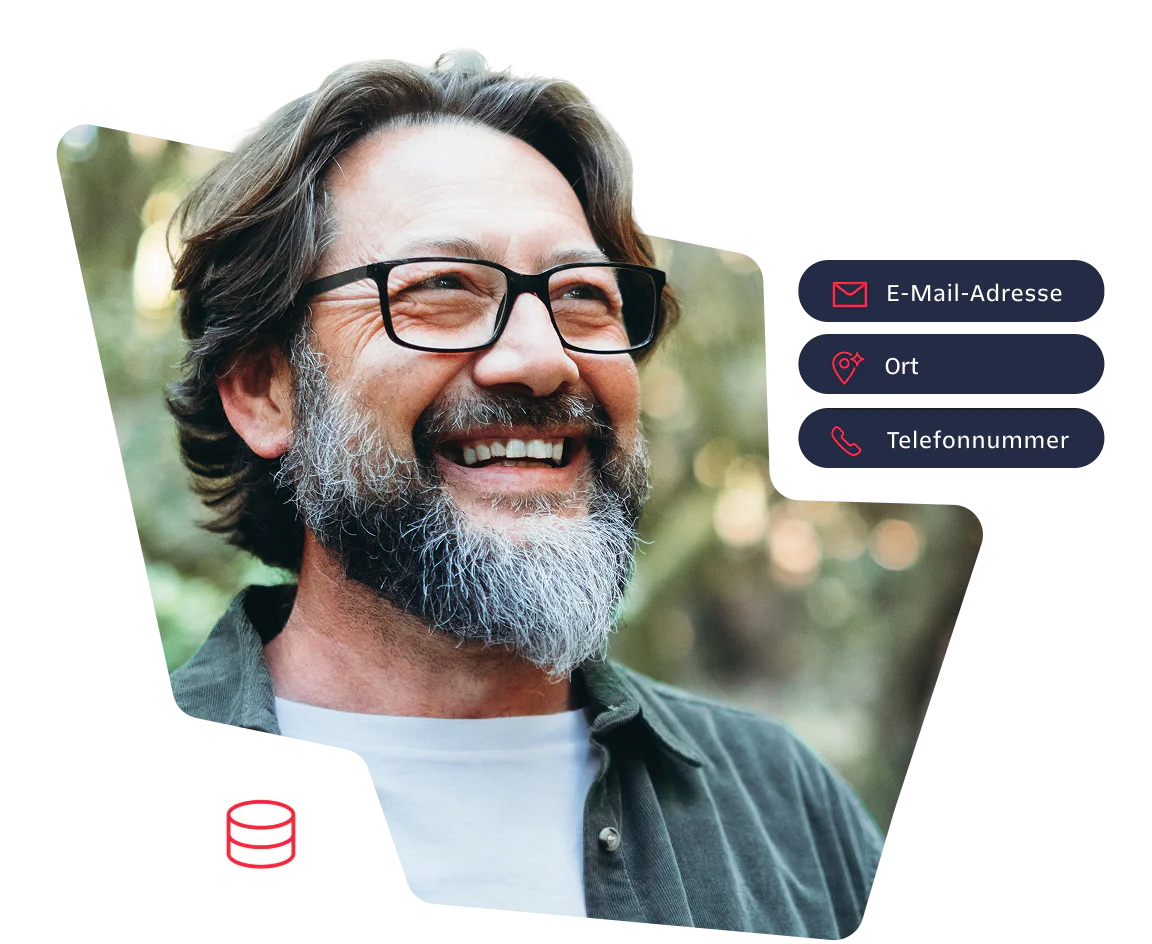 Smiling man with glasses and beard standing outdoors in a forest background.