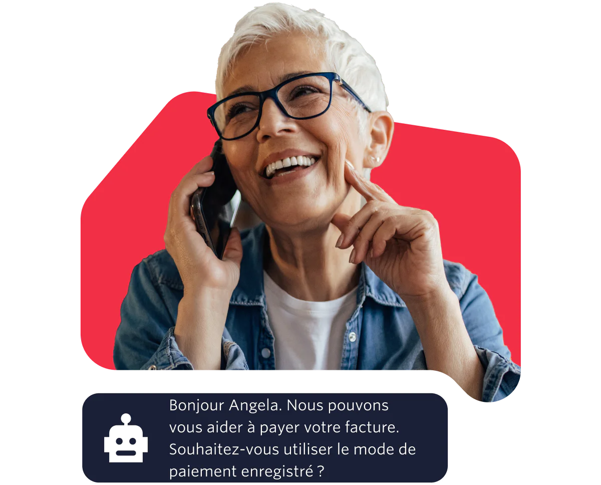 Elderly woman with glasses smiling while talking on the phone against a red background.