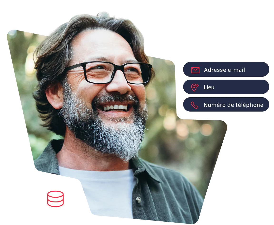 Smiling man with glasses and beard standing outdoors in a forest background.