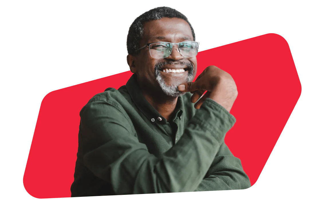 Man with glasses smiling and posing in a green shirt, red geometric background