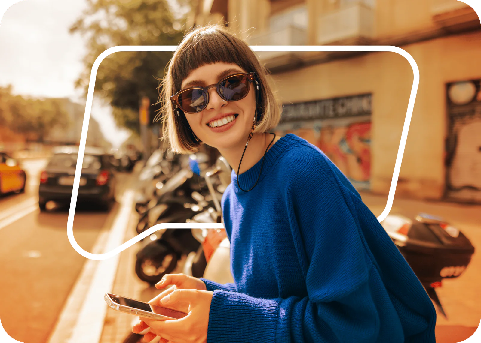 Woman wearing headphones, smiling and raising her arm while dancing near a window.