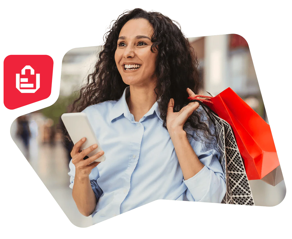 Smiling woman holding a smartphone and shopping bags with a blurred city background.