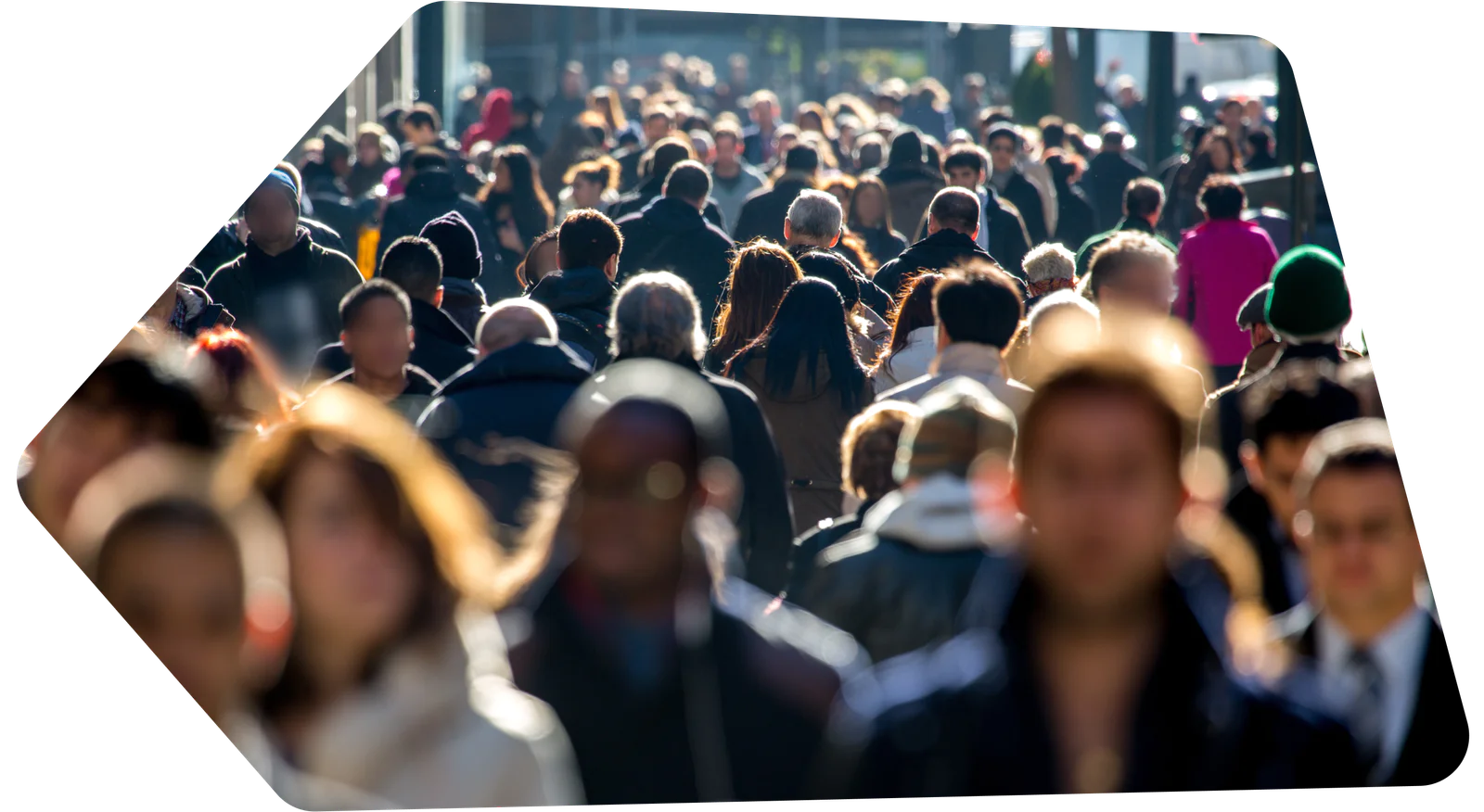 Large group of people walking on a busy street with a mix of blurred and focused figures.