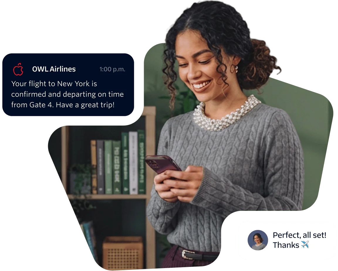 Woman smiling and looking at her phone while holding a flight confirmation message.