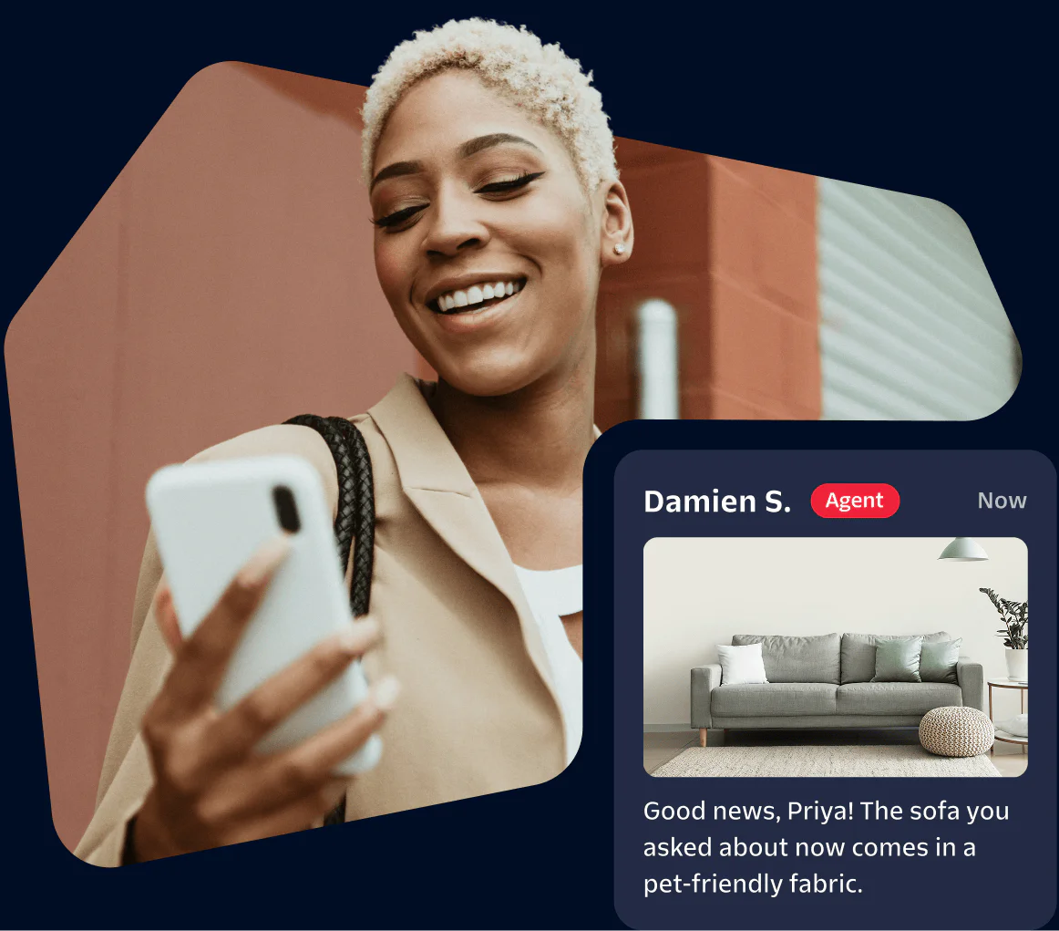 Smiling woman reading a message about a pet-friendly fabric sofa on her phone.