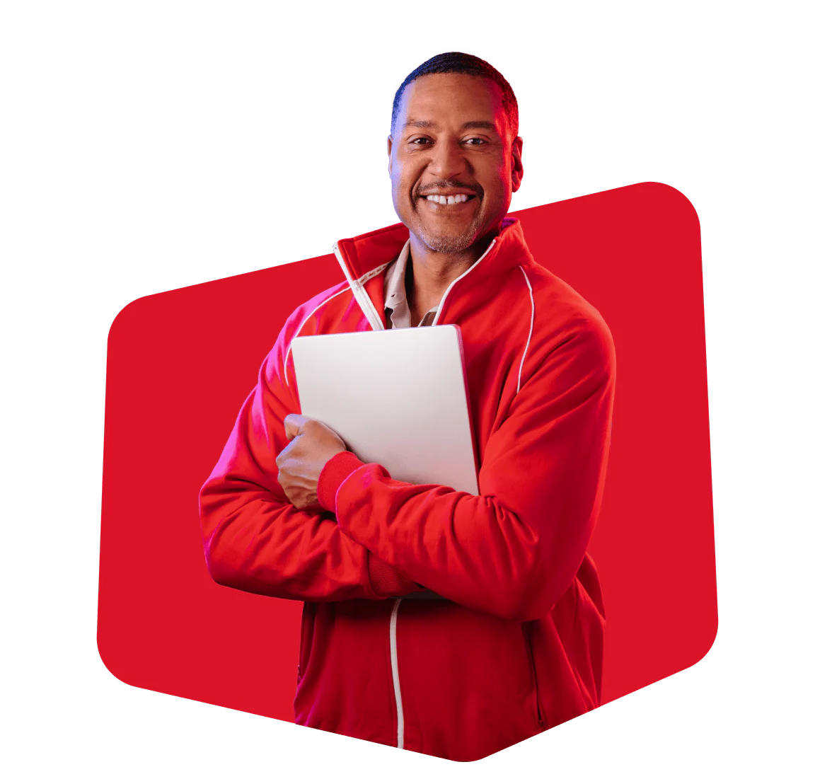 Man in a red jacket smiling while holding a laptop against a red geometric background