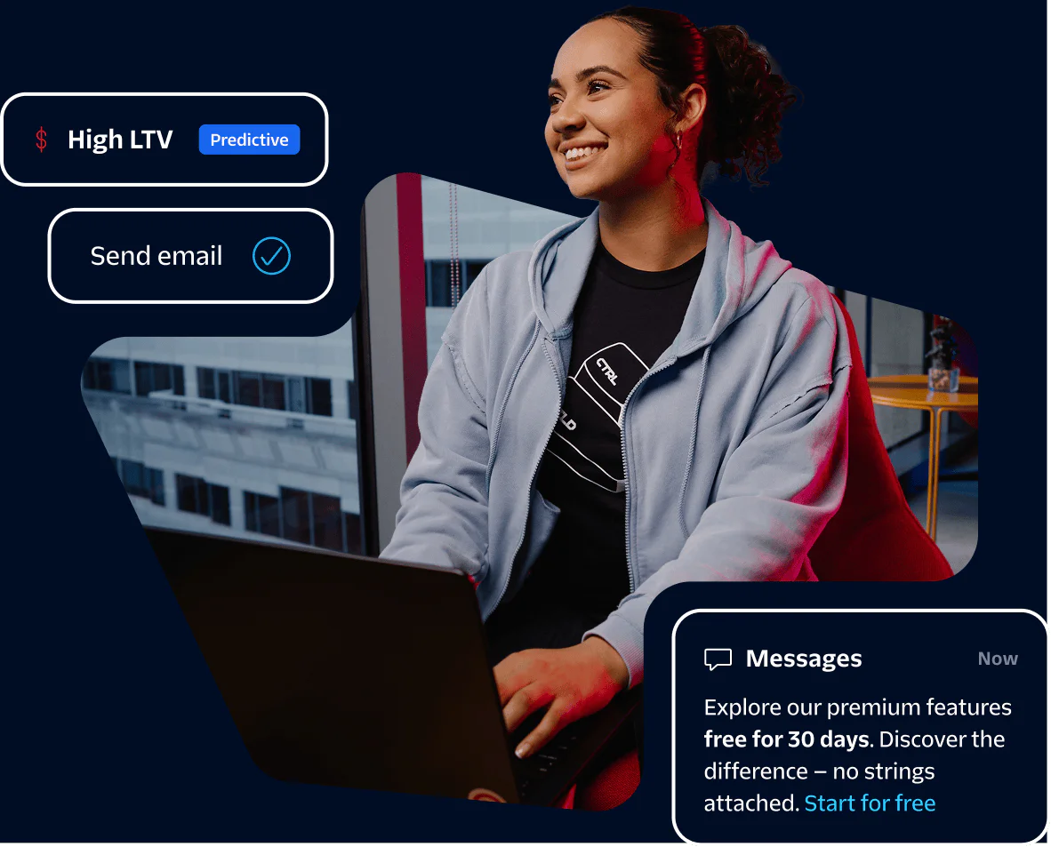 Woman in a hoodie using a laptop in an office with high LTV and messages notification on screen.